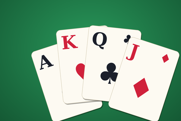 Solitaire: Ace, King, Queen and Jack fanned on green casino felt